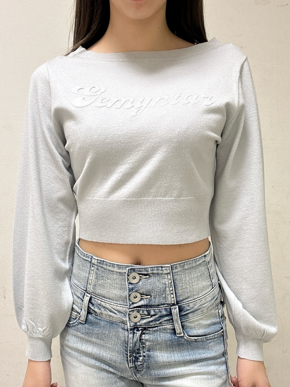 グレー系のニット/セーター、ブルー系のデニムパンツ、ブラック系のブーツを着用したレディースの冬コーディネートの2枚目の写真