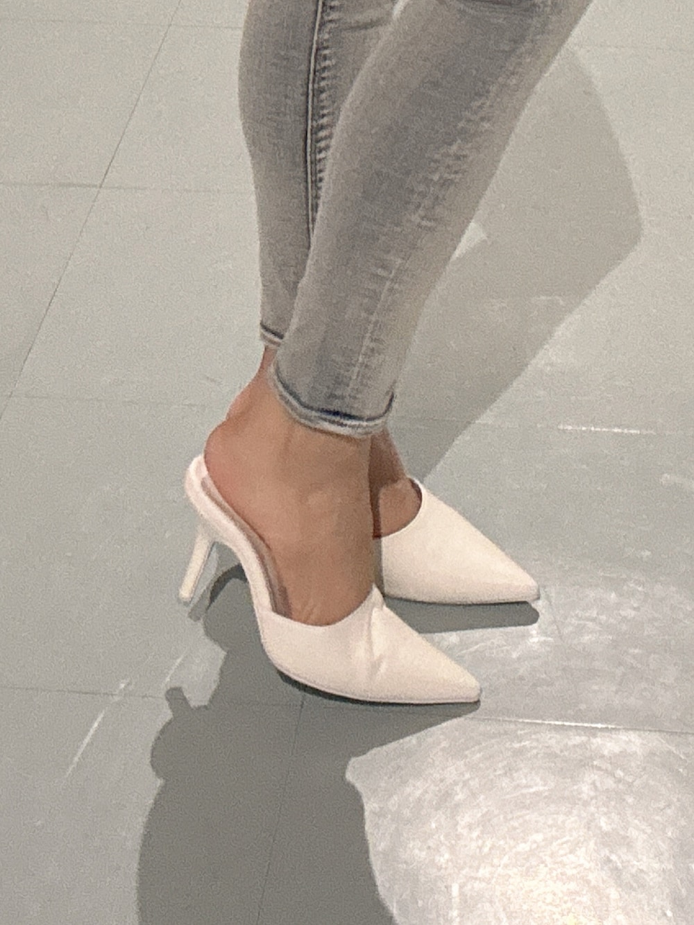 ブルー系のデニムパンツ、ホワイト系のニット/セーター、ホワイト系のパンプスを着用したレディースの春コーディネートの7枚目の写真