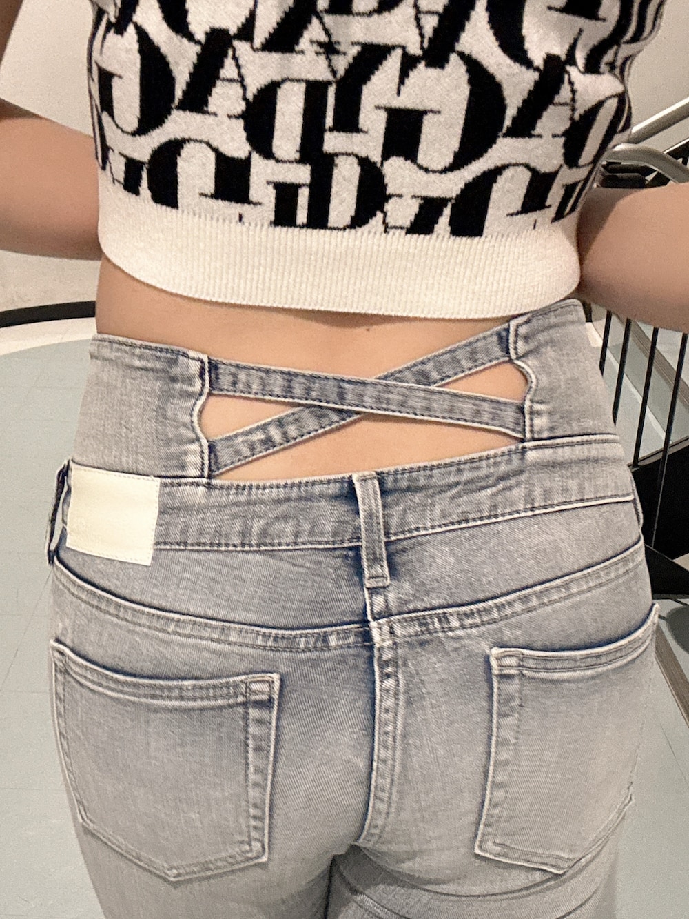 ブルー系のデニムパンツ、ホワイト系のニット/セーター、ホワイト系のパンプスを着用したレディースの春コーディネートの6枚目の写真