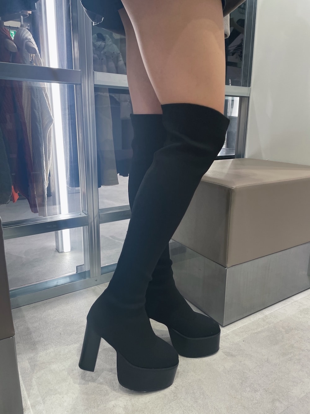 ベージュ系のパーカー、ブラック系のブーツ、ブラック系のスカートを着用したレディースの秋コーディネートの7枚目の写真