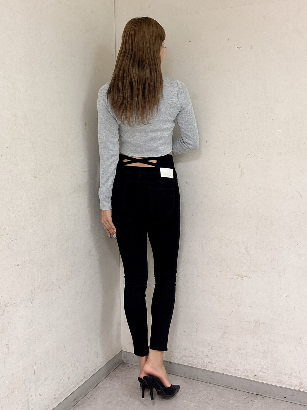 グレー系のニット/セーター、ブラック系のデニムパンツ、ブラック系のパンプスを着用したレディースの秋コーディネートの3枚目の写真