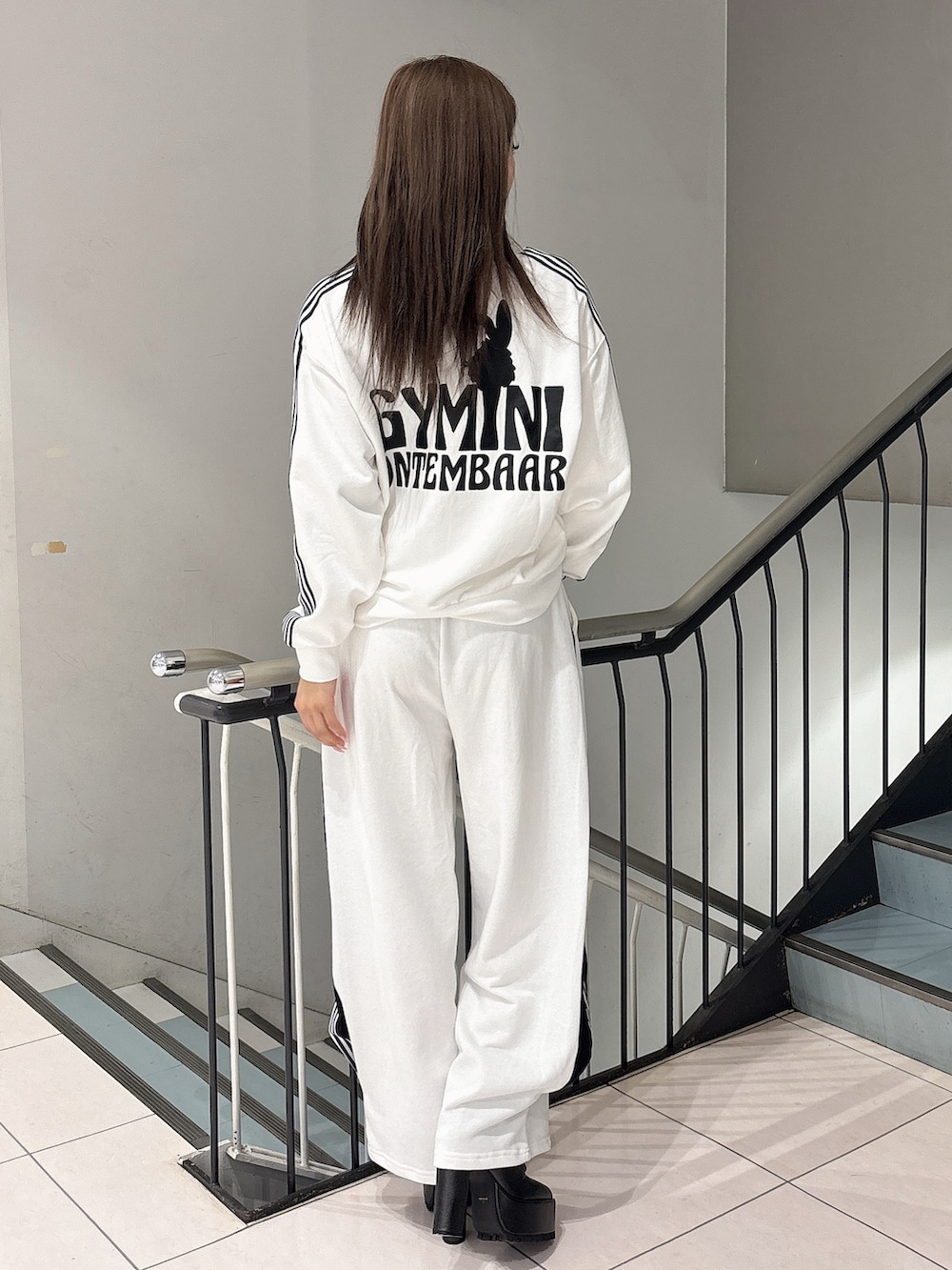 ホワイト系のスウェット、ホワイト系のスウェットパンツ、ブラック系のブーツを着用したレディースの冬コーディネートの3枚目の写真