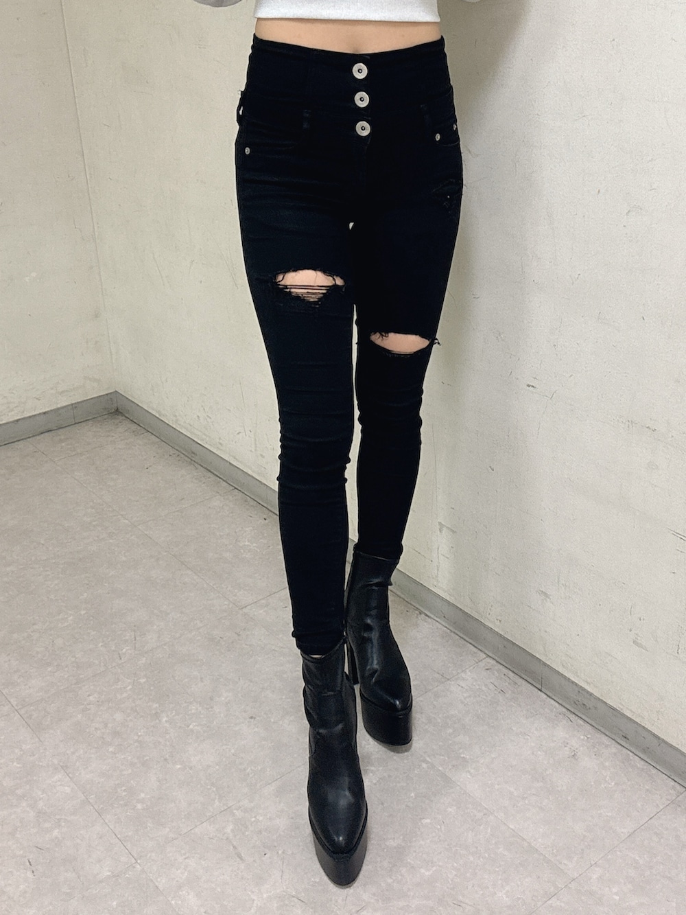 ホワイト系のTシャツ/カットソー、ブラック系のデニムパンツ、ブラック系のブーツを着用したレディースの冬コーディネートの5枚目の写真