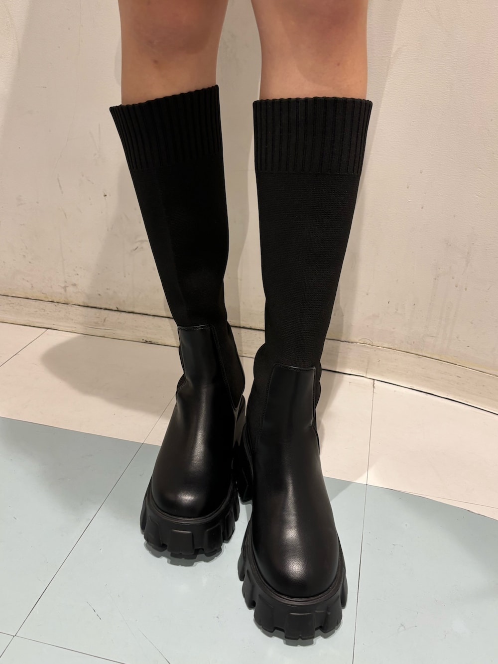 ブルー系のデニムスカート、ブラック系のブーツ、ブラック系のパーカーを着用したレディースの秋コーディネートの7枚目の写真