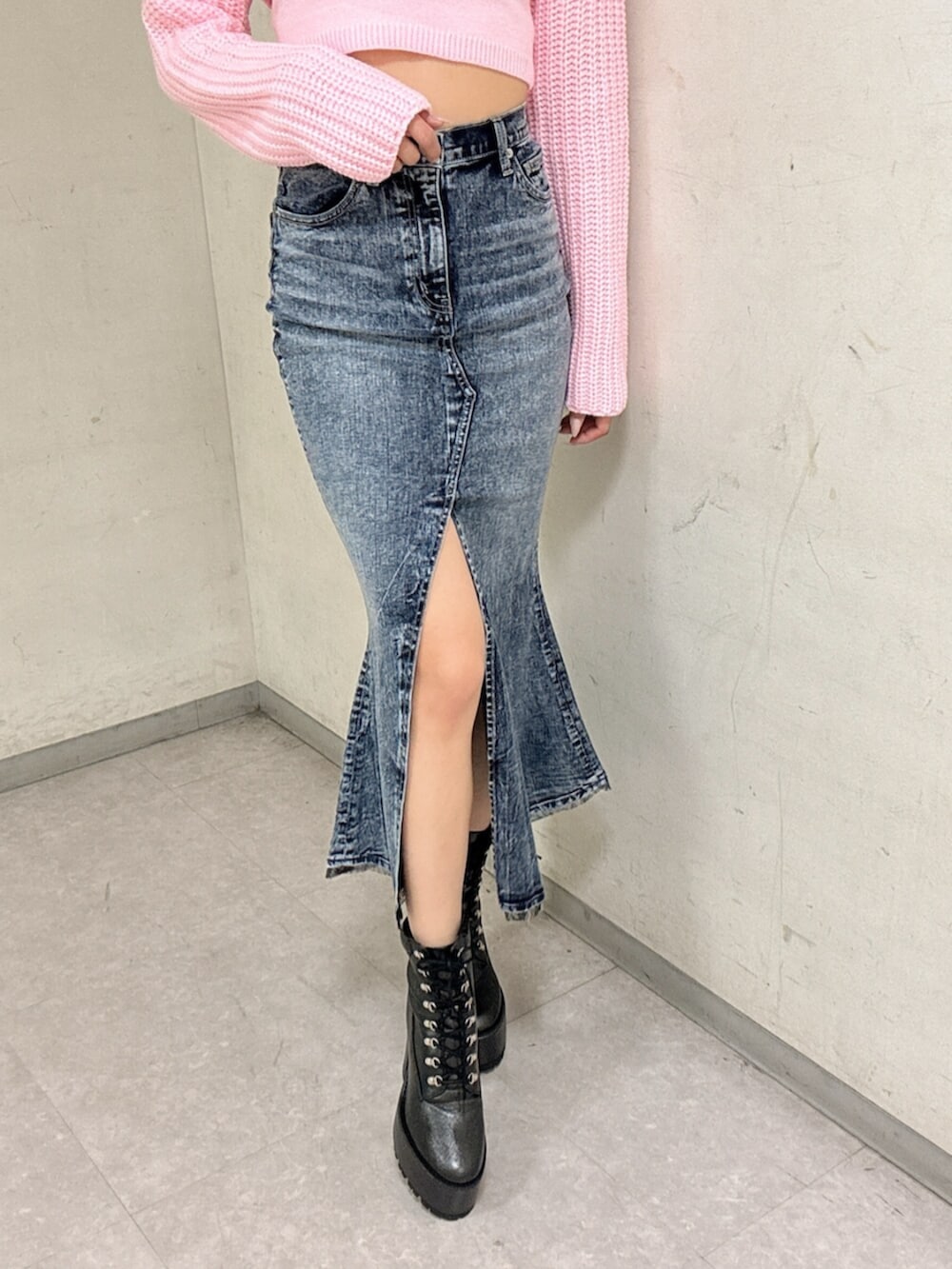 ブラック系のブーツ、ピンク系のニット/セーター、ブルー系のデニムスカートを着用したレディースの冬コーディネートの5枚目の写真