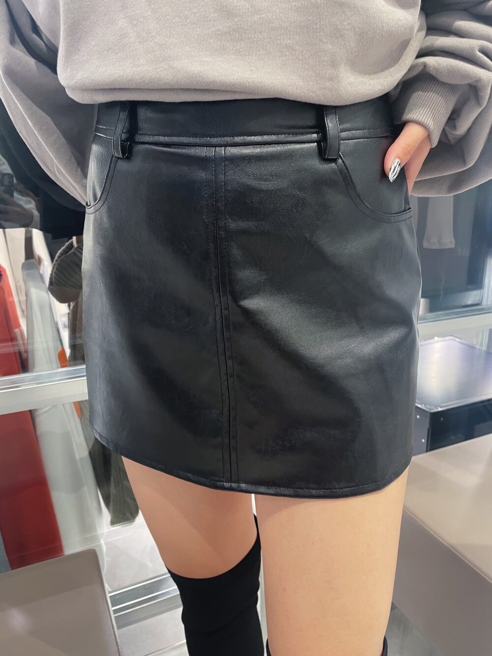 ベージュ系のパーカー、ブラック系のブーツ、ブラック系のスカートを着用したレディースの秋コーディネートの5枚目の写真