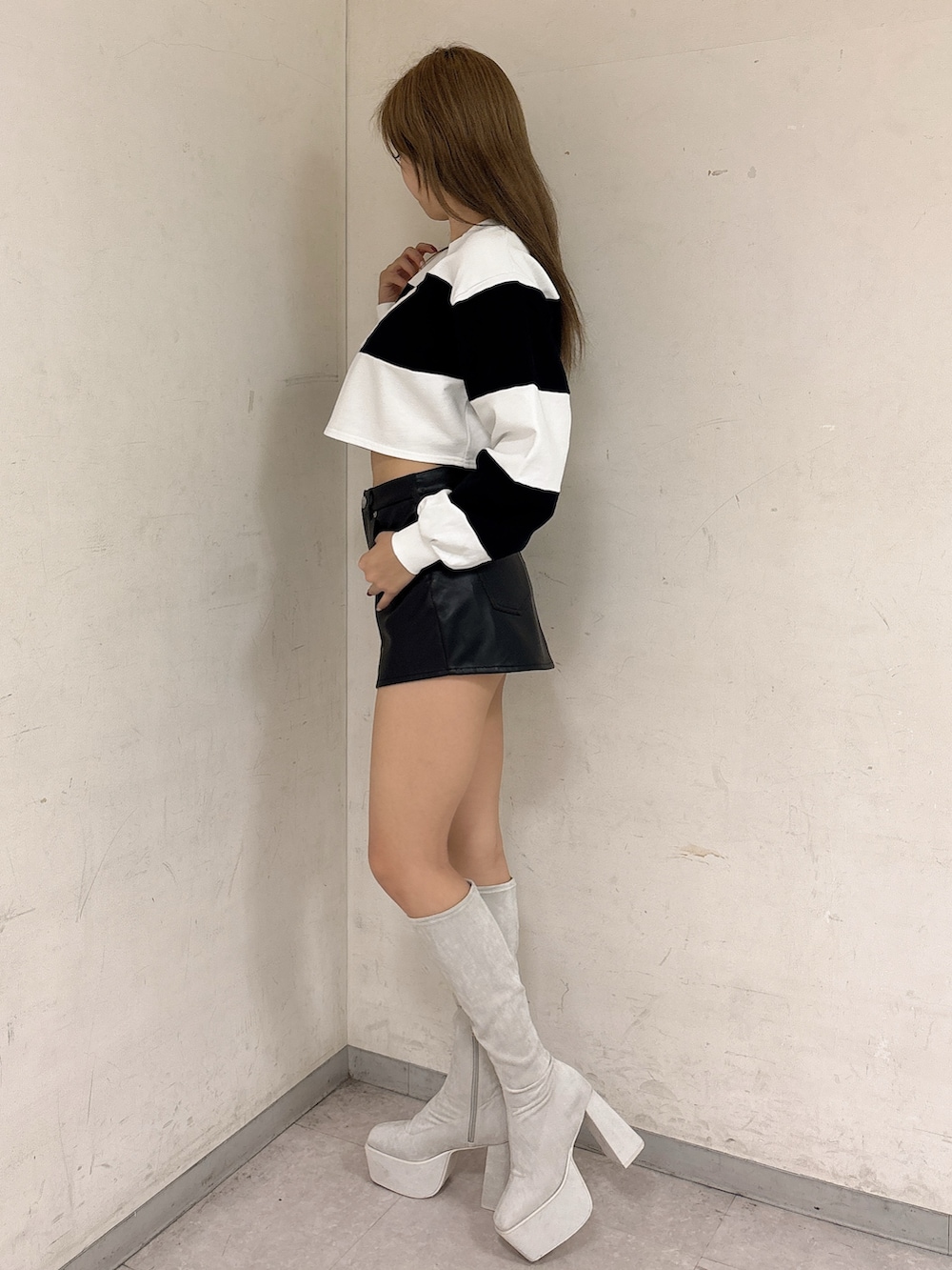 ホワイト系のTシャツ/カットソー、ブラック系のスカート、ホワイト系のブーツを着用したレディースの冬コーディネートの2枚目の写真