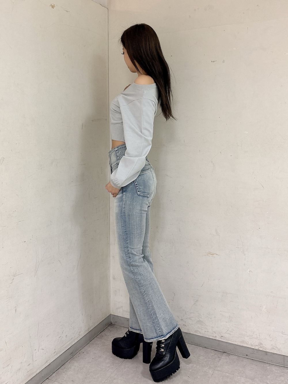 グレー系のニット/セーター、ブルー系のデニムパンツ、ブラック系のブーツを着用したレディースの冬コーディネートの3枚目の写真