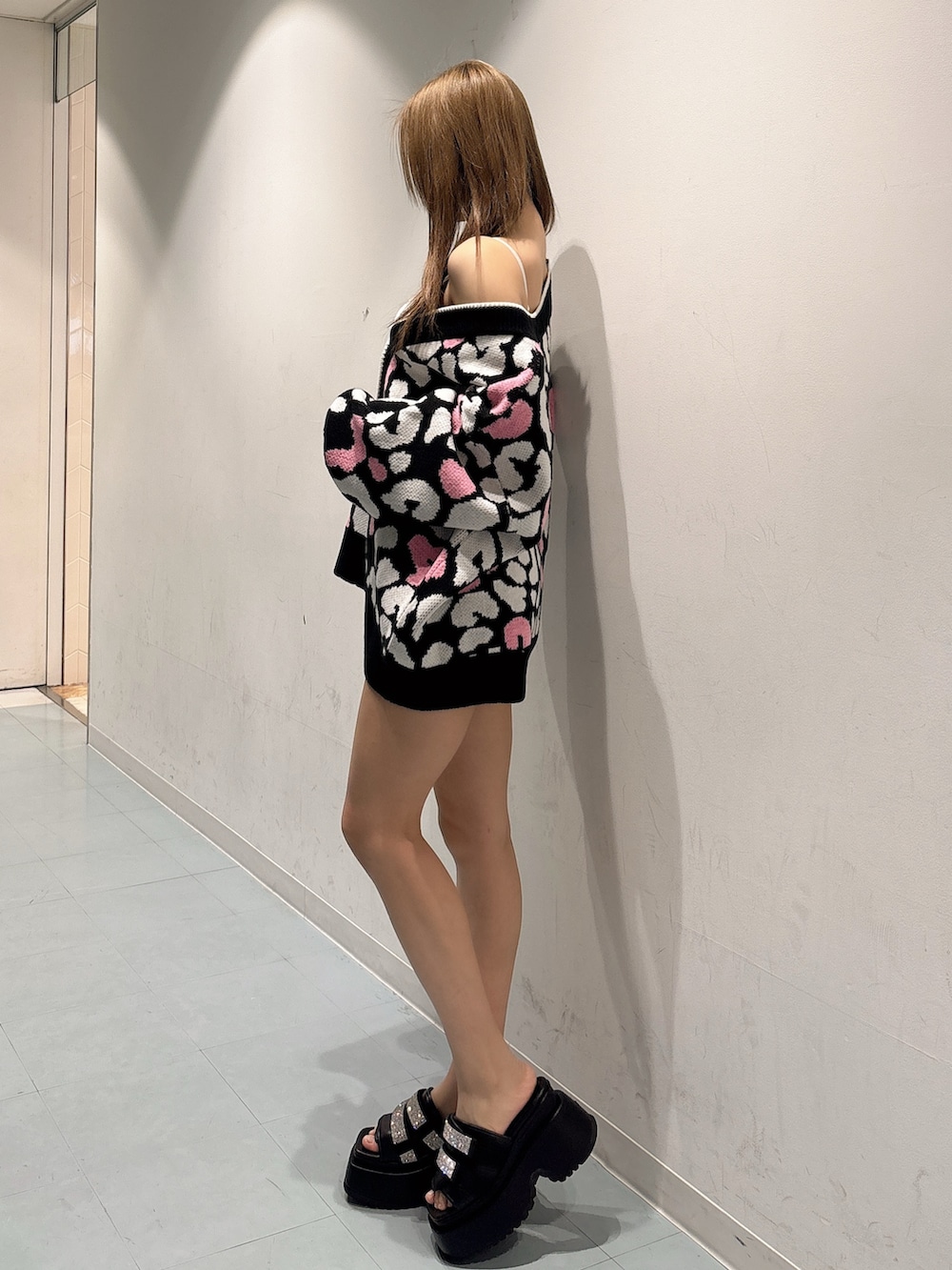 ブラック系のカーディガン/ボレロ、ブラック系のデニムパンツ、ホワイト系のキャミソールを着用したレディースの春コーディネートの2枚目の写真