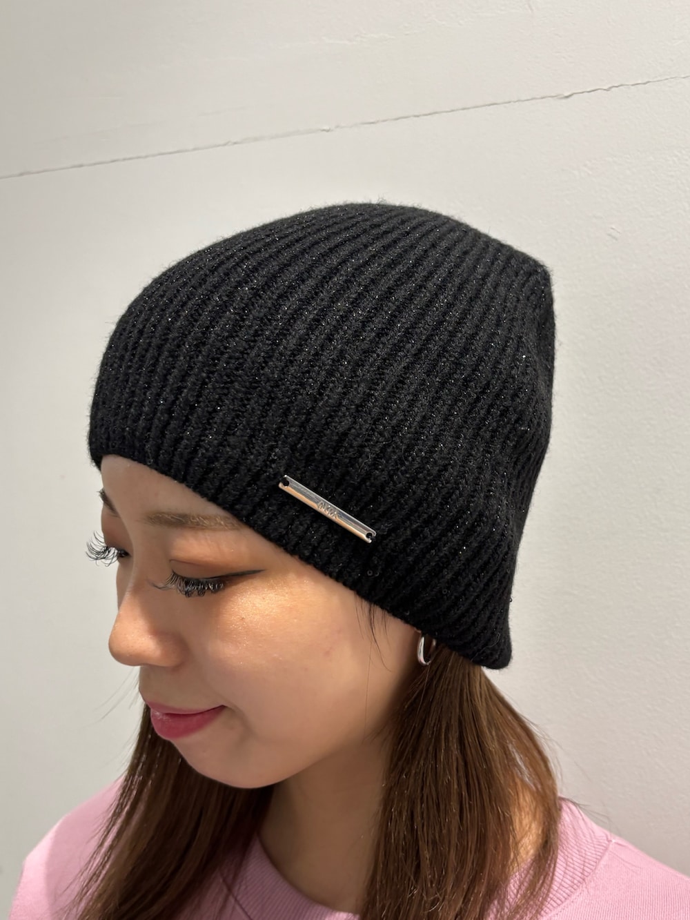 ピンク系のスウェット、ブラック系のハンドバッグ、ブラック系のブーツを着用したレディースの冬コーディネートの7枚目の写真