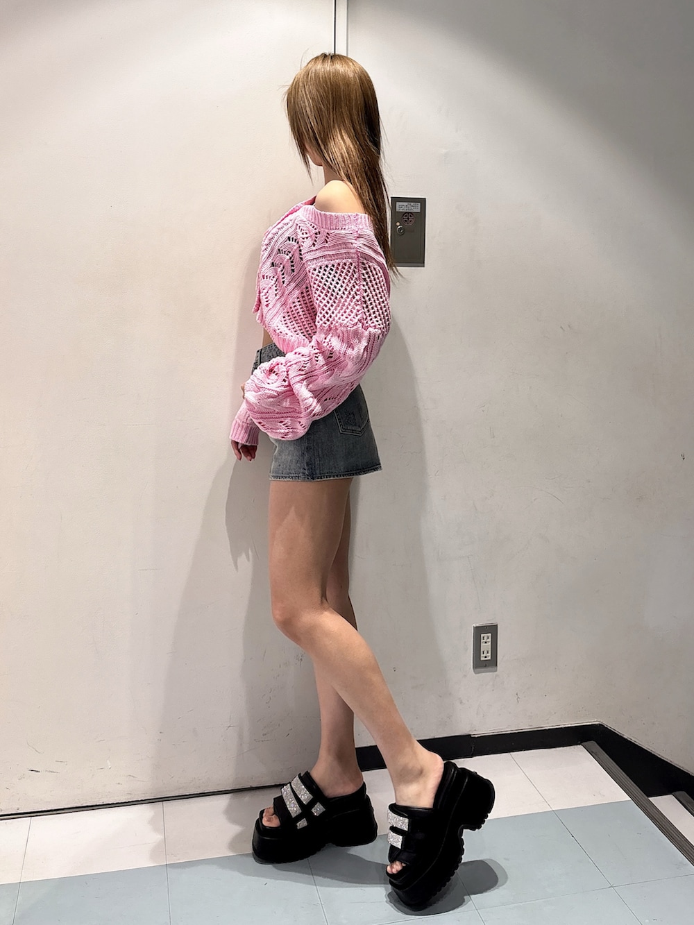 ブラック系のサンダル、ブルー系のデニムスカート、ピンク系のニット/セーターを着用したレディースの春コーディネートの2枚目の写真