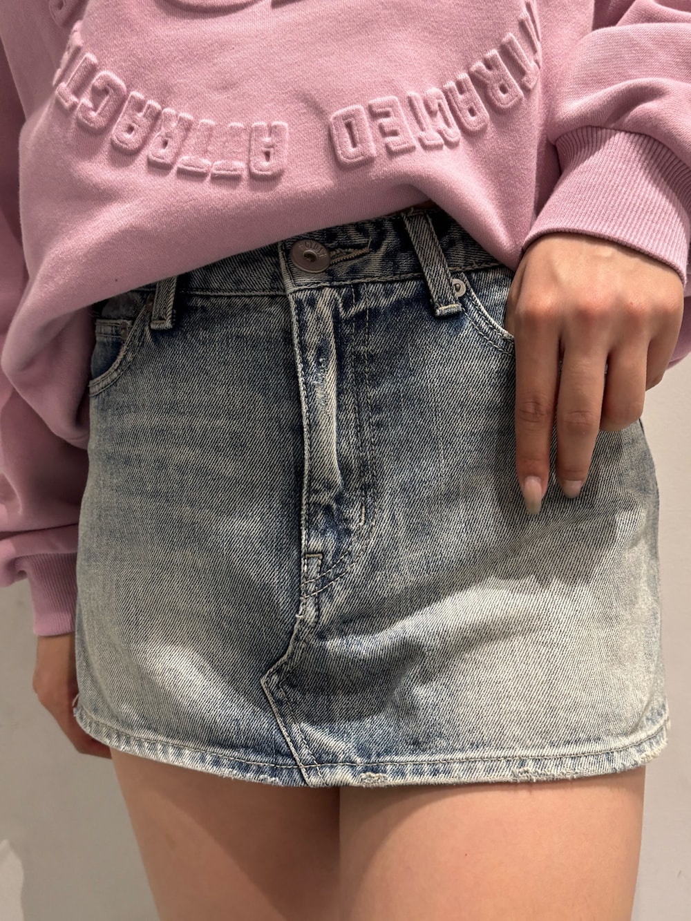 ピンク系のスウェット、ブラック系のハンドバッグ、ブラック系のブーツを着用したレディースの冬コーディネートの5枚目の写真