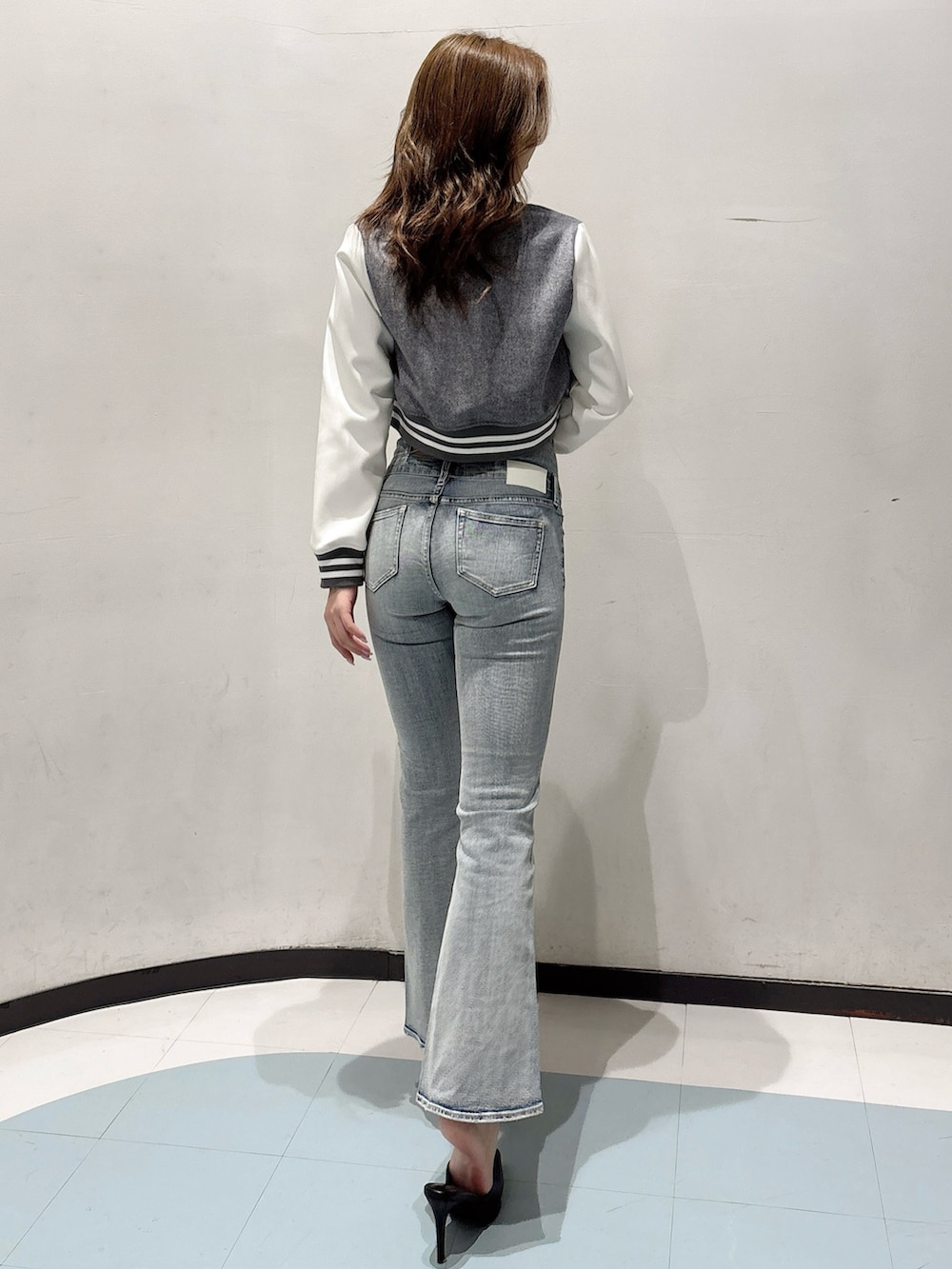 ブラック系のパンプス、グレー系のブルゾン、ホワイト系のキャミソールを着用したレディースの冬コーディネートの3枚目の写真