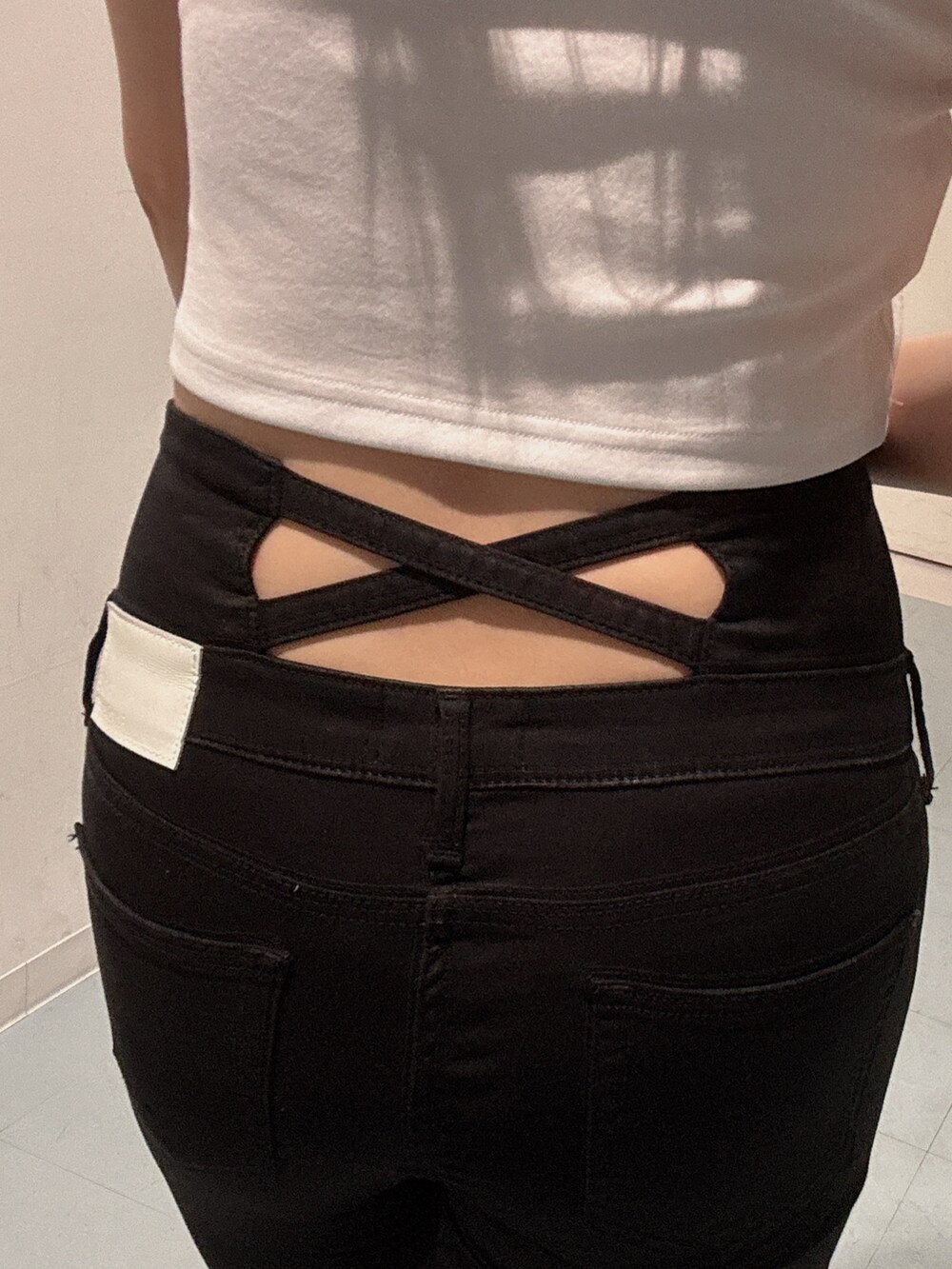 ブラック系のデニムパンツ、ホワイト系のサンダル、ホワイト系のTシャツ/カットソーを着用したレディースの春コーディネートの6枚目の写真