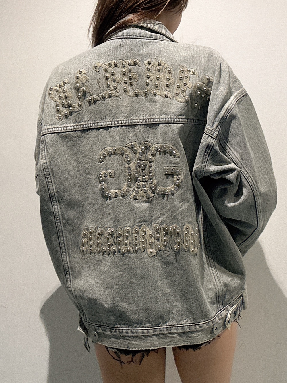 ブルー系のデニムジャケット、ブラック系のデニムパンツ、ブラック系のチューブトップを着用したレディースの春コーディネートの4枚目の写真