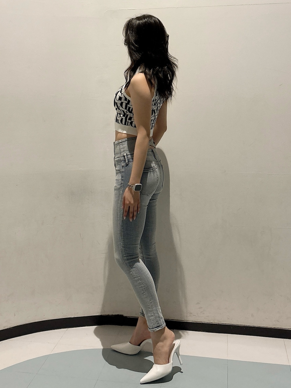 ブルー系のデニムパンツ、ホワイト系のニット/セーター、ホワイト系のパンプスを着用したレディースの春コーディネートの2枚目の写真