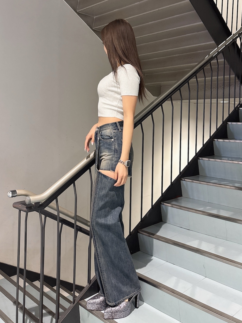 ホワイト系のニット/セーター、ブルー系のデニムパンツ、グレー系のパンプスを着用したレディースの春コーディネートの2枚目の写真