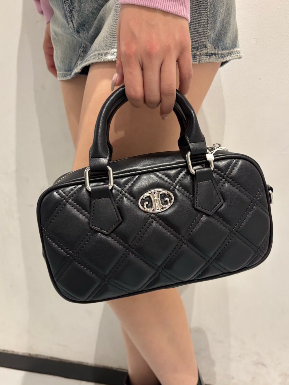 ピンク系のスウェット、ブラック系のハンドバッグ、ブラック系のブーツを着用したレディースの冬コーディネートの6枚目の写真