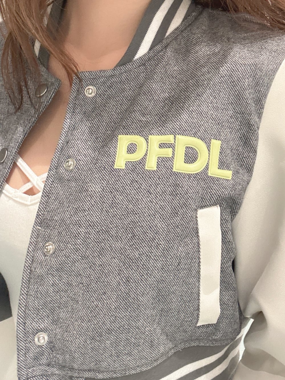 ブラック系のパンプス、グレー系のブルゾン、ホワイト系のキャミソールを着用したレディースの冬コーディネートの5枚目の写真