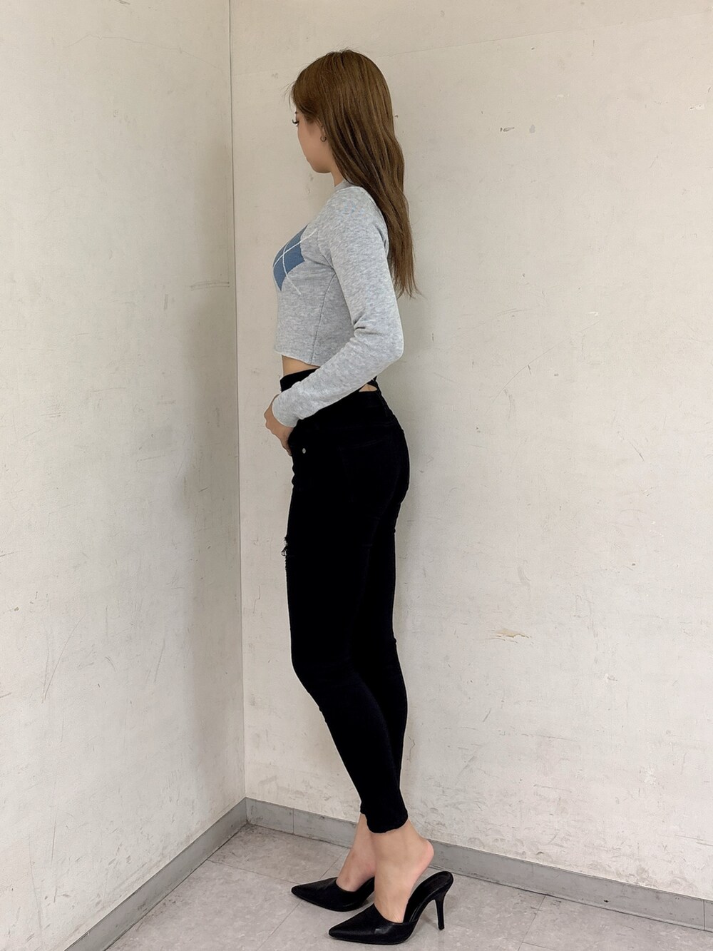 グレー系のニット/セーター、ブラック系のデニムパンツ、ブラック系のパンプスを着用したレディースの秋コーディネートの2枚目の写真