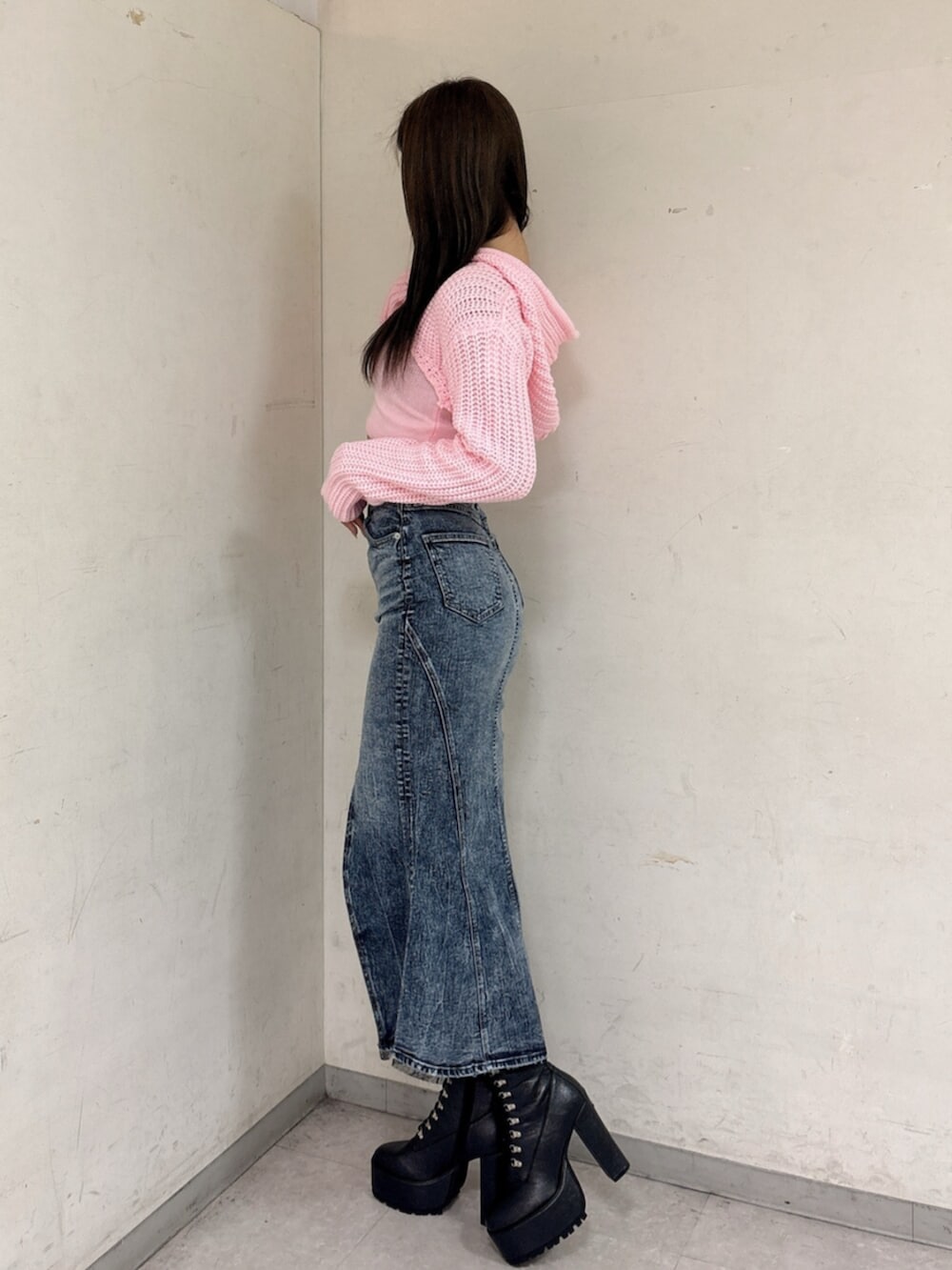 ブラック系のブーツ、ピンク系のニット/セーター、ブルー系のデニムスカートを着用したレディースの冬コーディネートの2枚目の写真