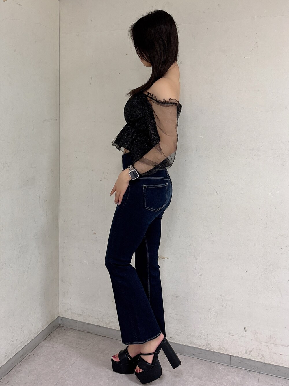 ブルー系のデニムパンツ、ブラック系のサンダル、ブラック系のシャツ/ブラウスを着用したレディースの春コーディネートの2枚目の写真