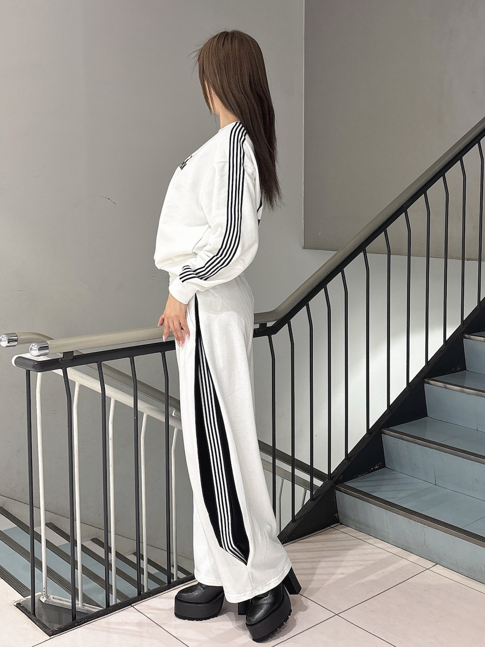 ホワイト系のスウェット、ホワイト系のスウェットパンツ、ブラック系のブーツを着用したレディースの冬コーディネートの2枚目の写真