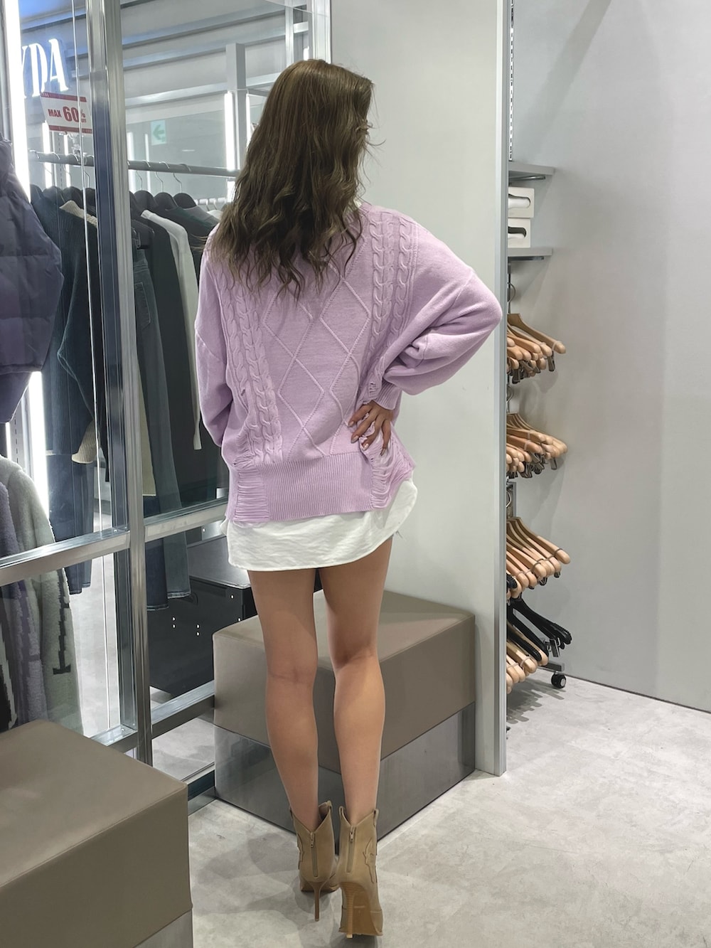 パープル系のニット/セーター、ホワイト系のシャツ/ブラウス、ブルー系のデニムパンツを着用したレディースの冬コーディネートの2枚目の写真