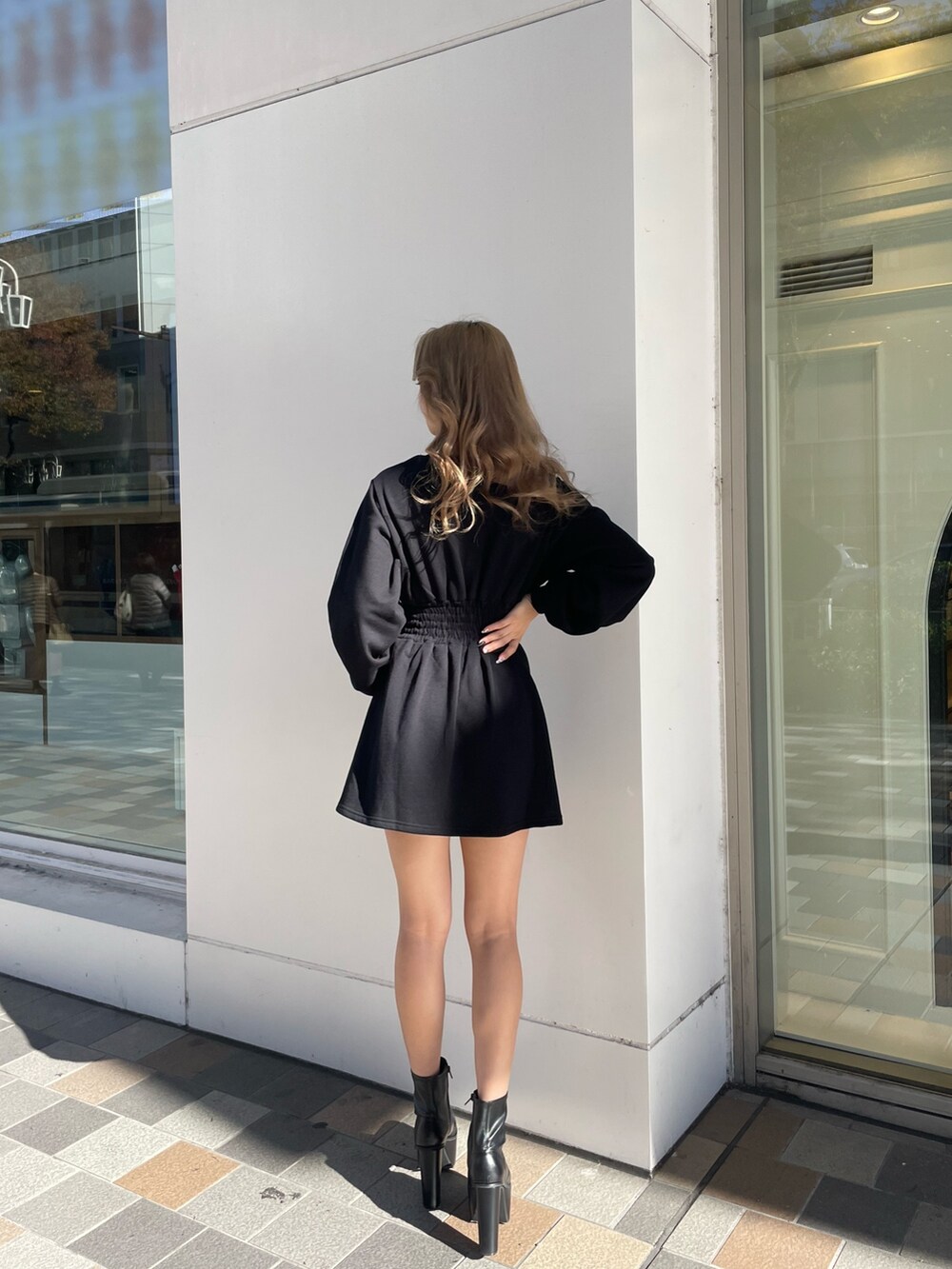 ブラック系のワンピース、ブラック系のブーツを着用したレディースの冬コーディネートの2枚目の写真