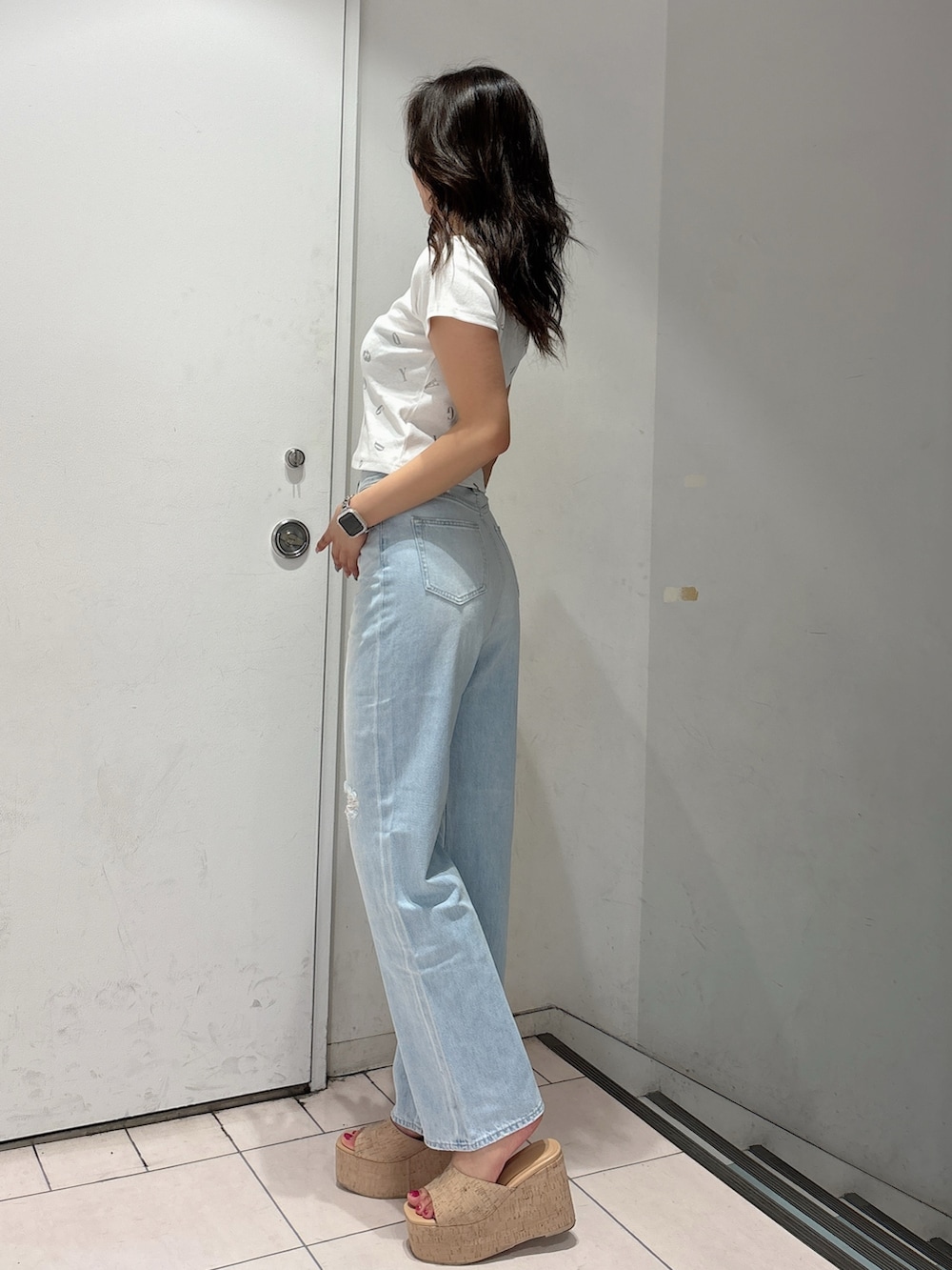 ホワイト系のサンダル、ブルー系のデニムパンツ、ホワイト系のTシャツ/カットソーを着用したレディースの春コーディネートの2枚目の写真