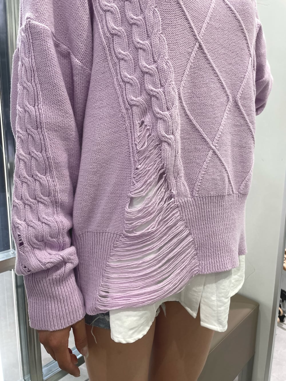 パープル系のニット/セーター、ホワイト系のシャツ/ブラウス、ブルー系のデニムパンツを着用したレディースの冬コーディネートの4枚目の写真