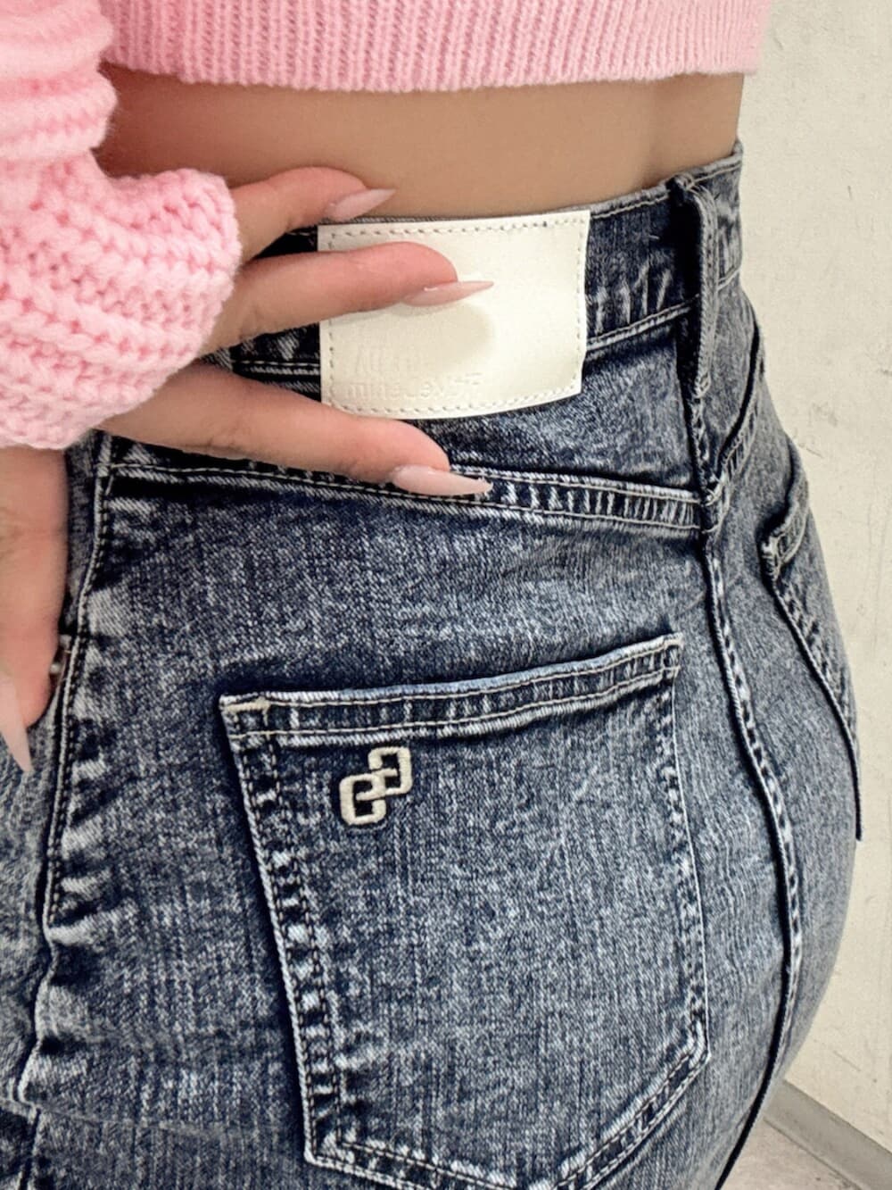 ブラック系のブーツ、ピンク系のニット/セーター、ブルー系のデニムスカートを着用したレディースの冬コーディネートの6枚目の写真