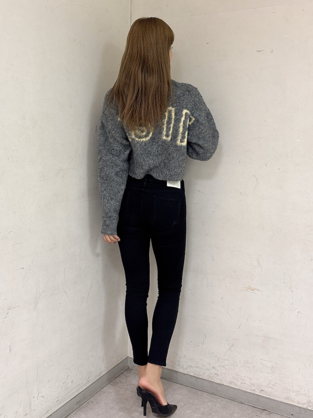 グレー系のカーディガン/ボレロ、ブラック系のデニムパンツ、ブラック系のパンプスを着用したレディースの秋コーディネートの3枚目の写真