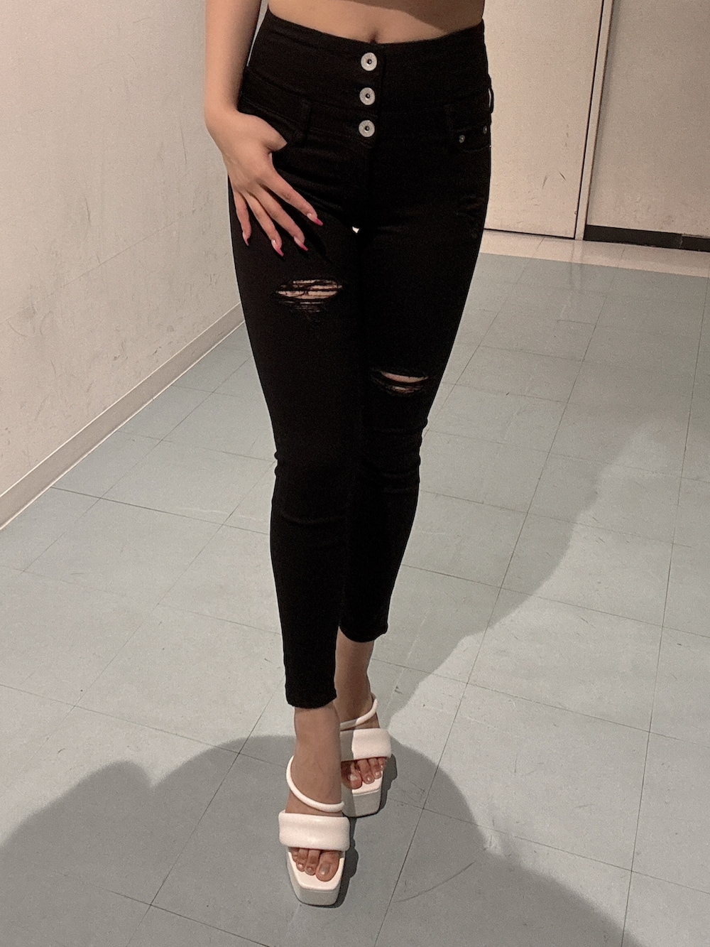 ブラック系のデニムパンツ、ホワイト系のサンダル、ホワイト系のTシャツ/カットソーを着用したレディースの春コーディネートの5枚目の写真