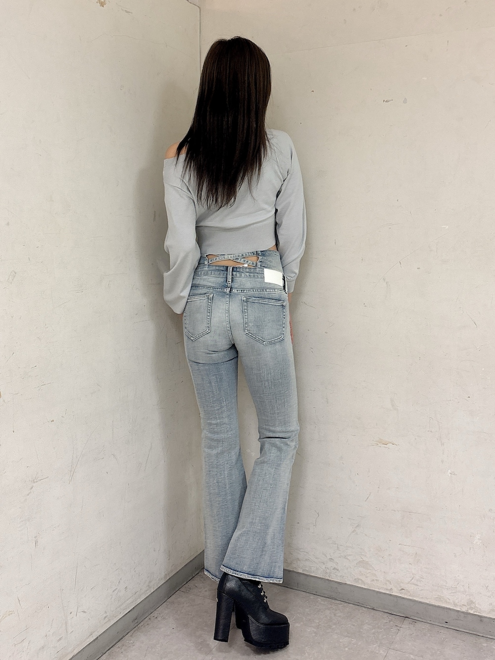 グレー系のニット/セーター、ブルー系のデニムパンツ、ブラック系のブーツを着用したレディースの冬コーディネートの4枚目の写真