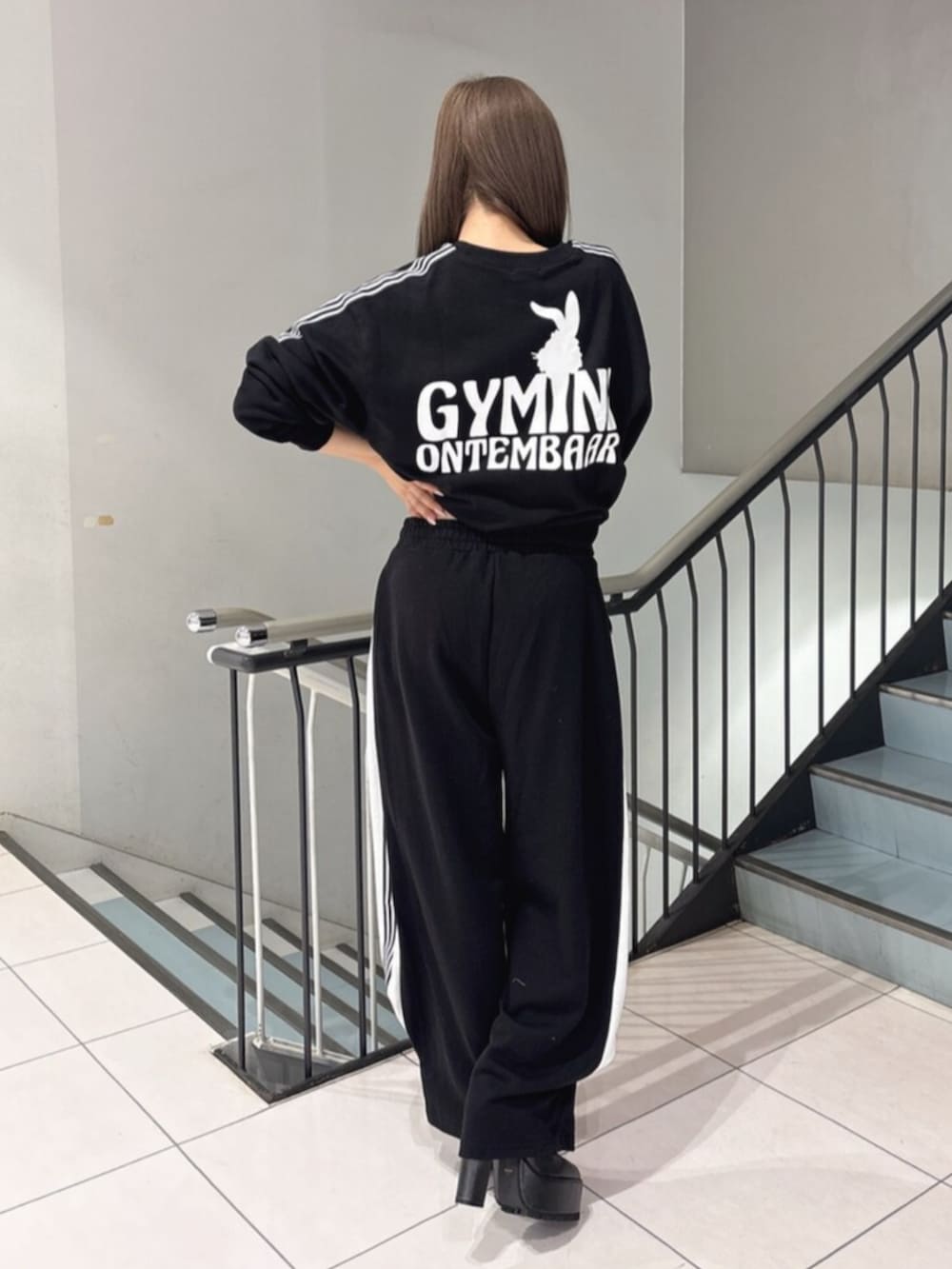 ブラック系のスウェット、ブラック系のスウェットパンツ、ブラック系のブーツを着用したレディースの冬コーディネートの3枚目の写真