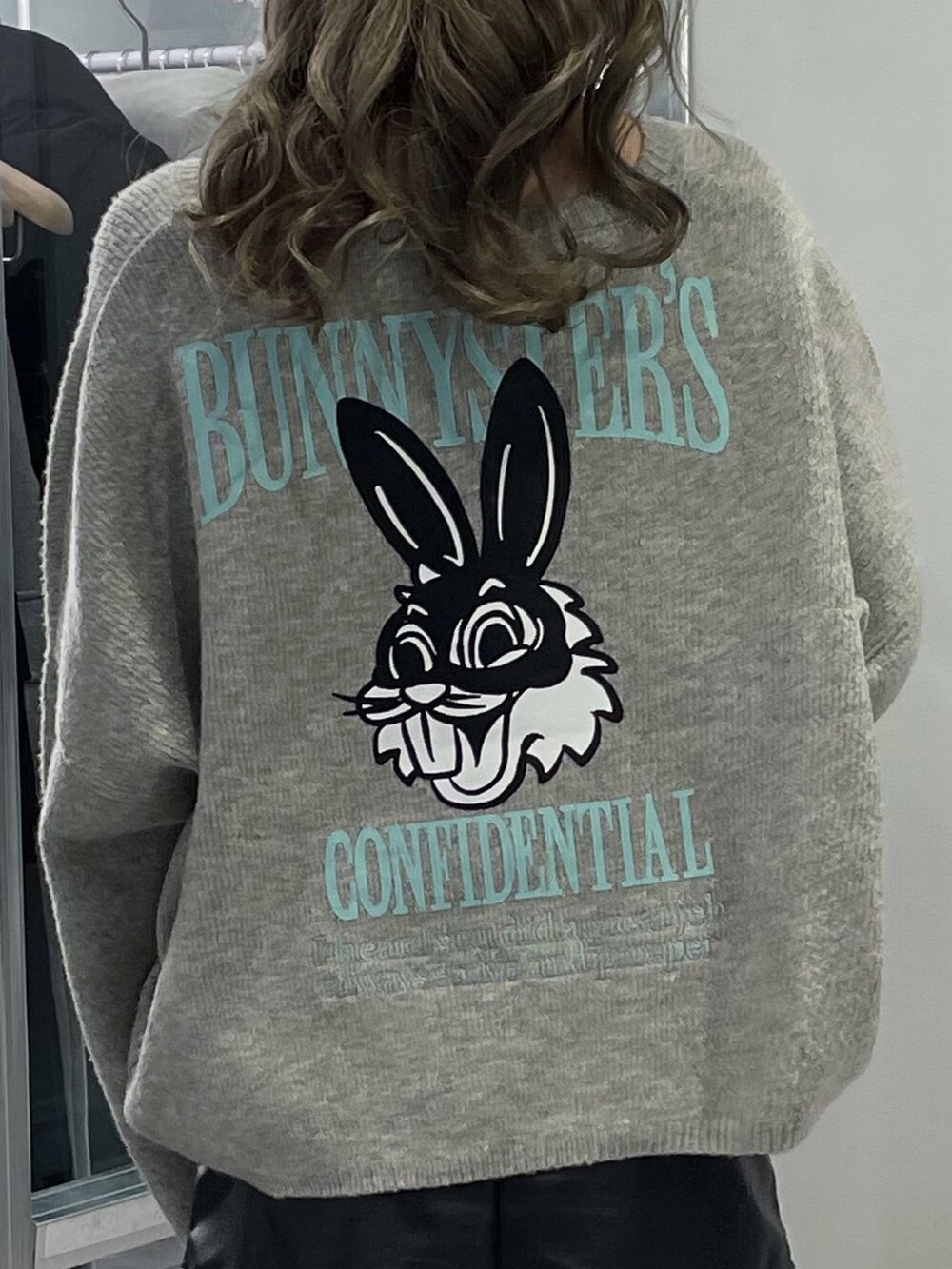 グレー系のニット/セーター、ブラック系のスカート、ブラック系のブーツを着用したレディースの冬コーディネートの4枚目の写真