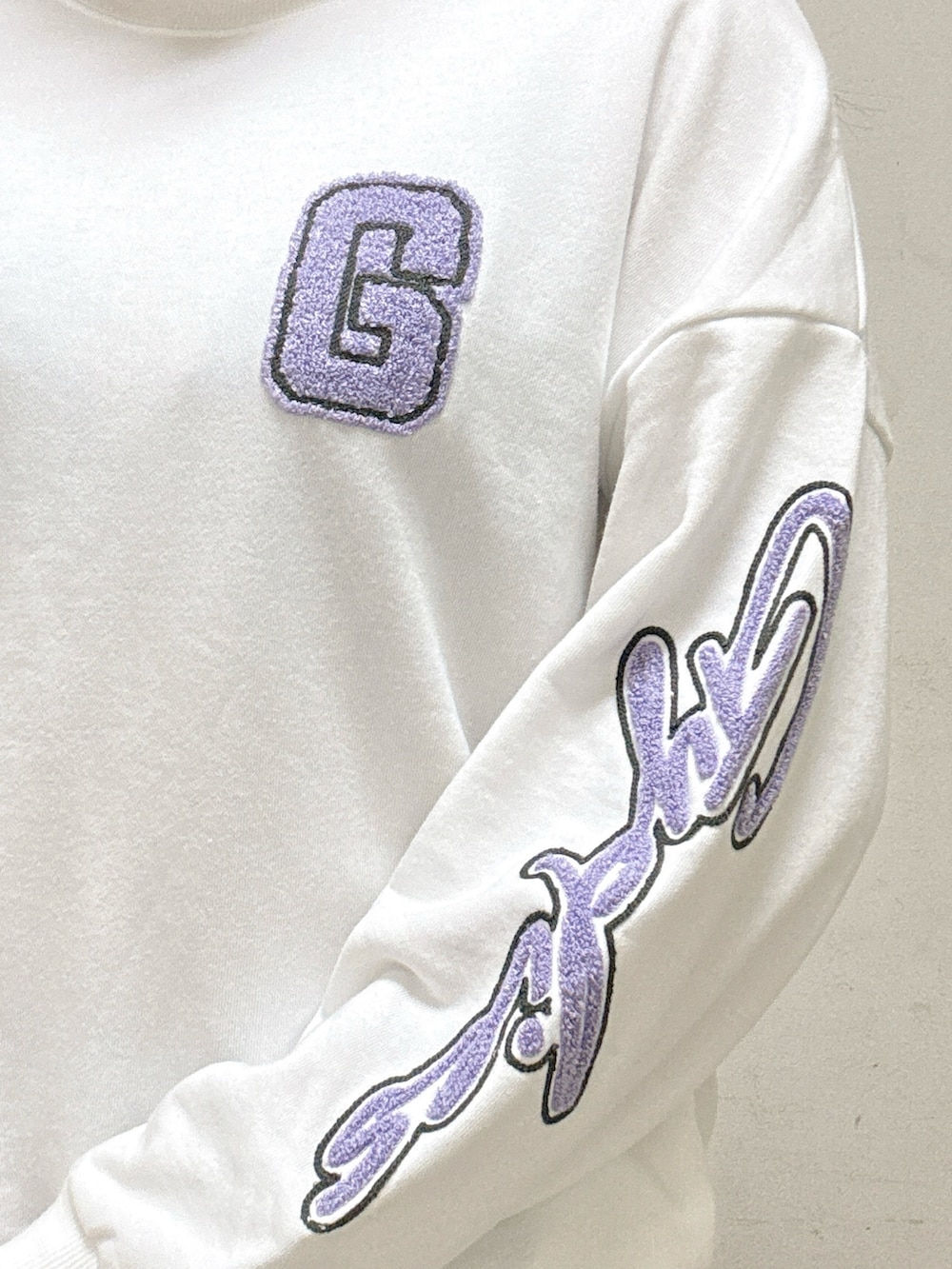 ホワイト系のスウェット、ブルー系のデニムパンツ、ブラック系のパンプスを着用したレディースの秋コーディネートの4枚目の写真