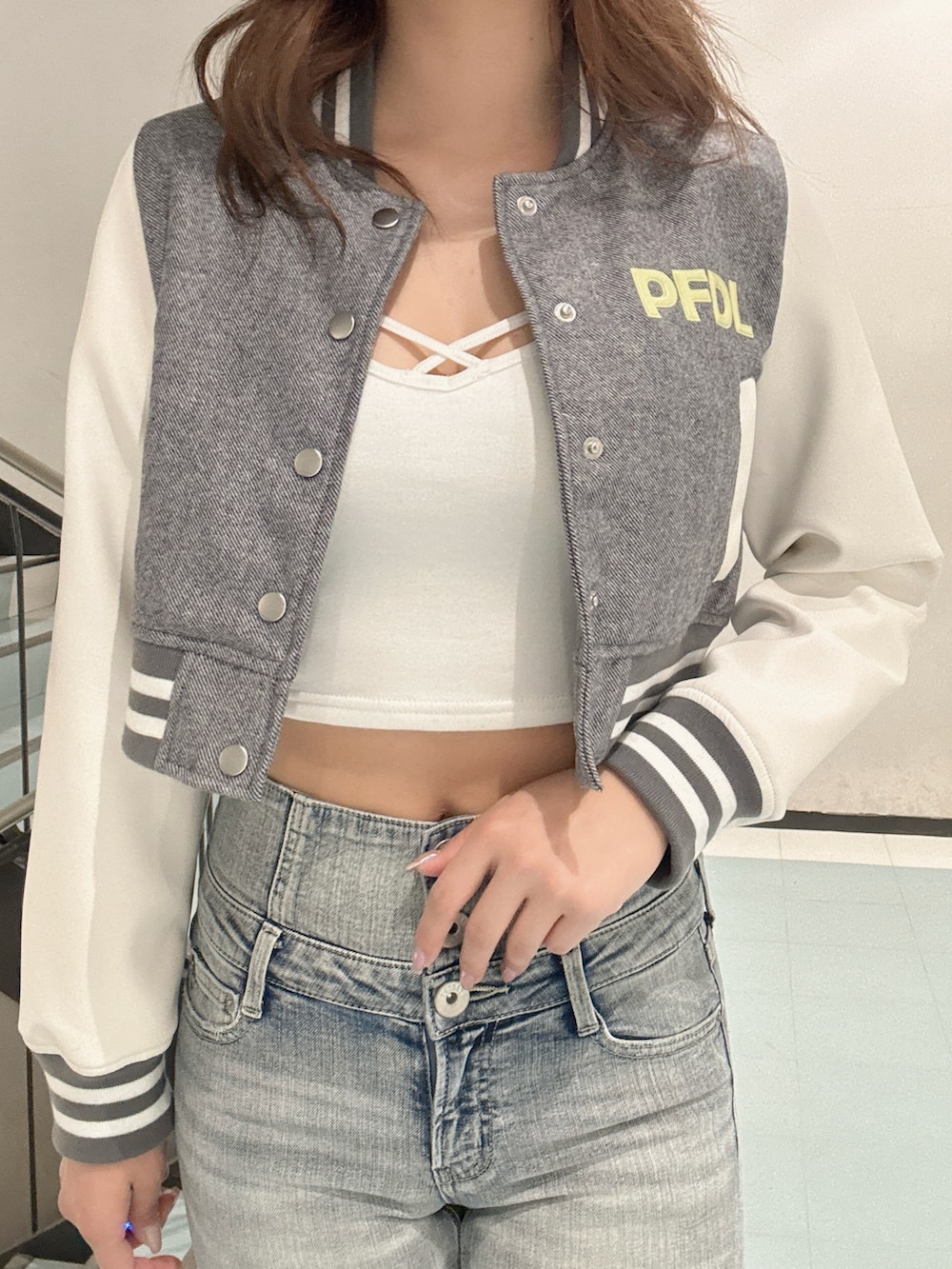 ブラック系のパンプス、グレー系のブルゾン、ホワイト系のキャミソールを着用したレディースの冬コーディネートの4枚目の写真