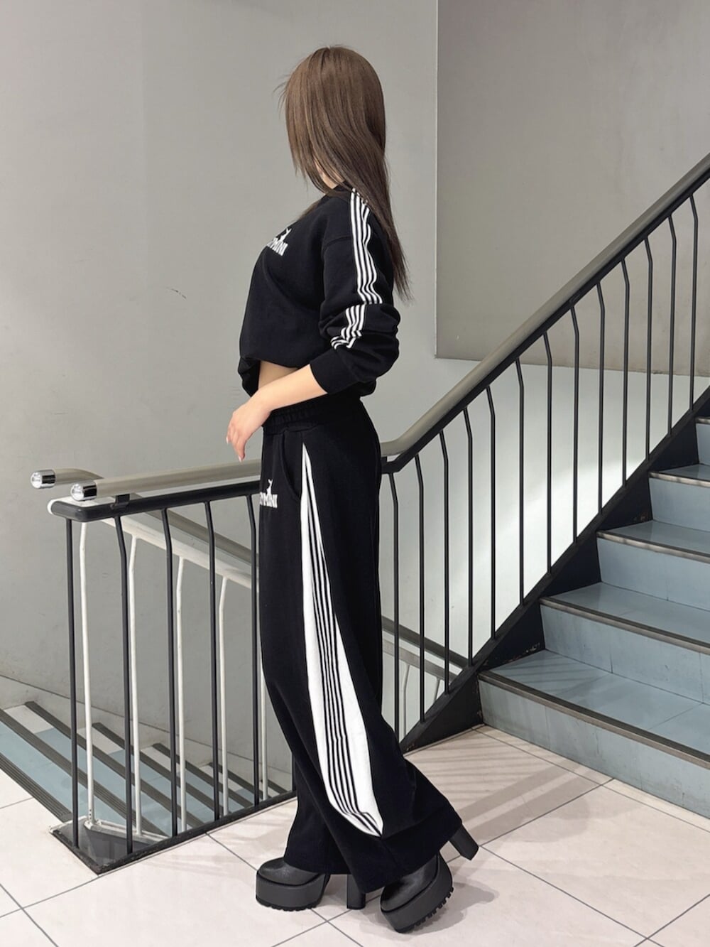 ブラック系のスウェット、ブラック系のスウェットパンツ、ブラック系のブーツを着用したレディースの冬コーディネートの2枚目の写真