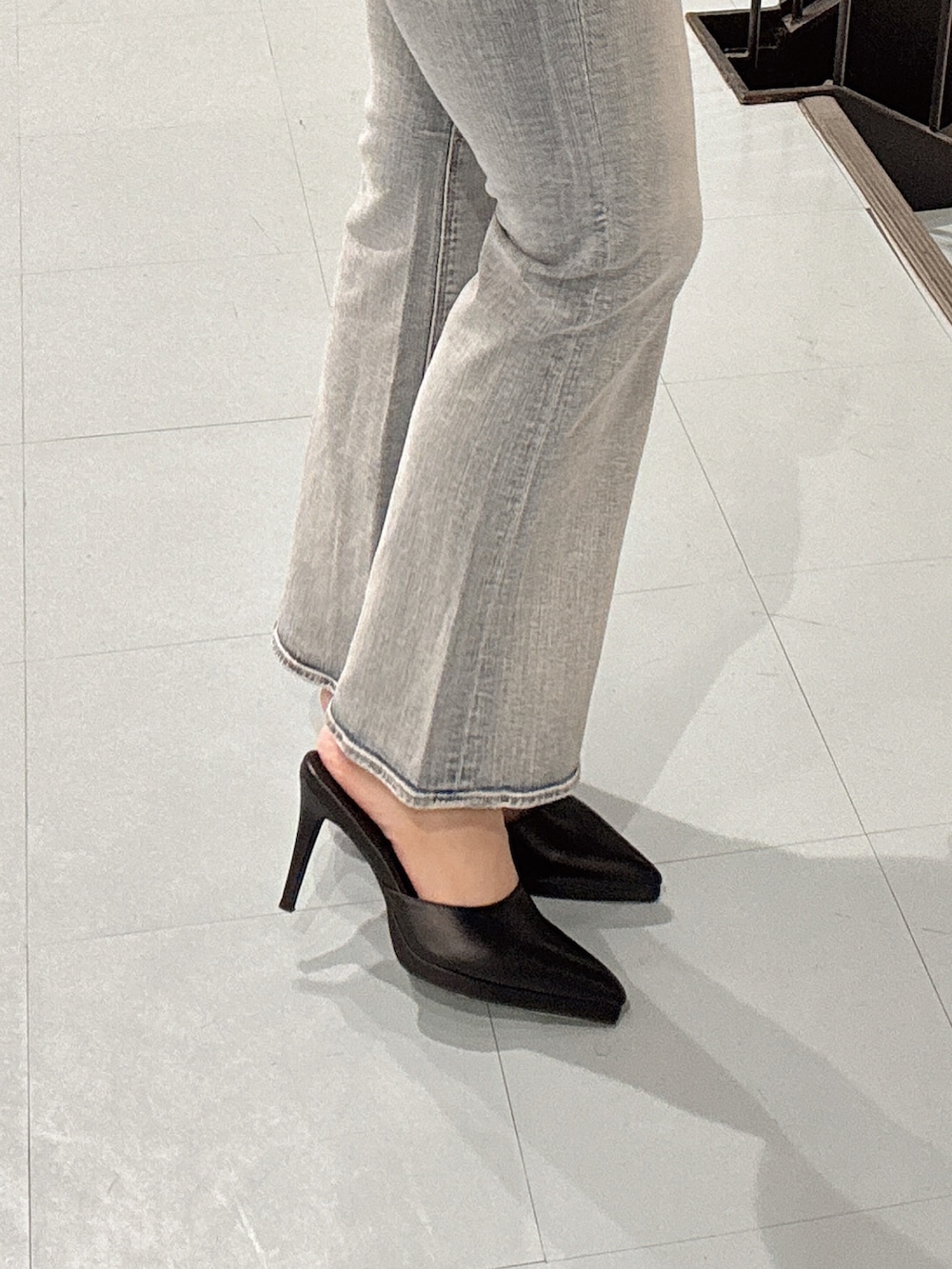 ブラック系のパンプス、グレー系のブルゾン、ホワイト系のキャミソールを着用したレディースの冬コーディネートの7枚目の写真