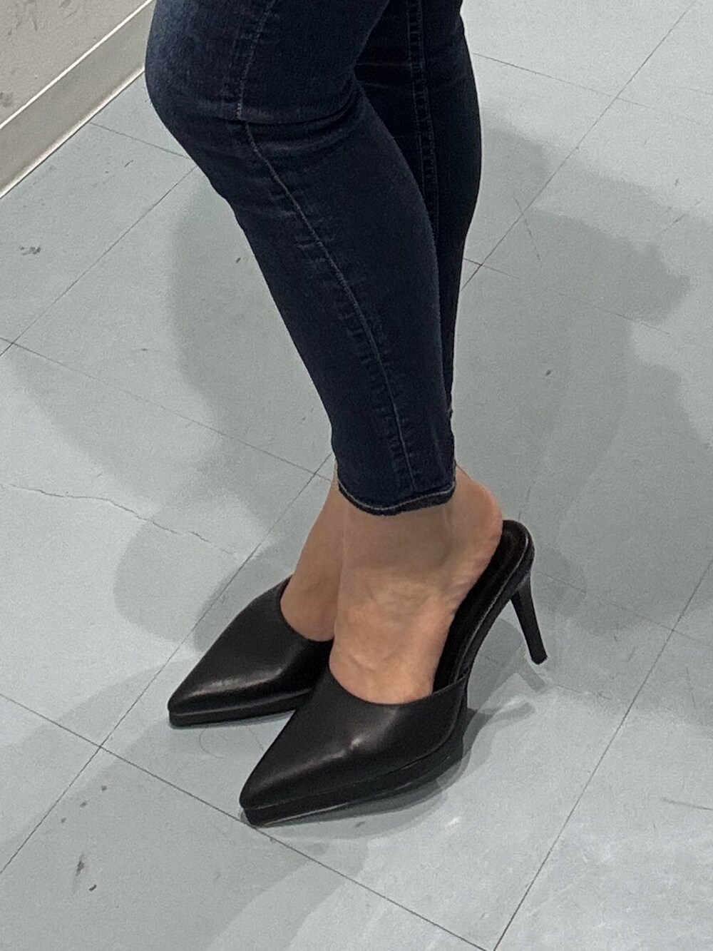 ブルー系のデニムパンツ、ブラック系のニット/セーター、ブラック系のパンプスを着用したレディースの冬コーディネートの7枚目の写真