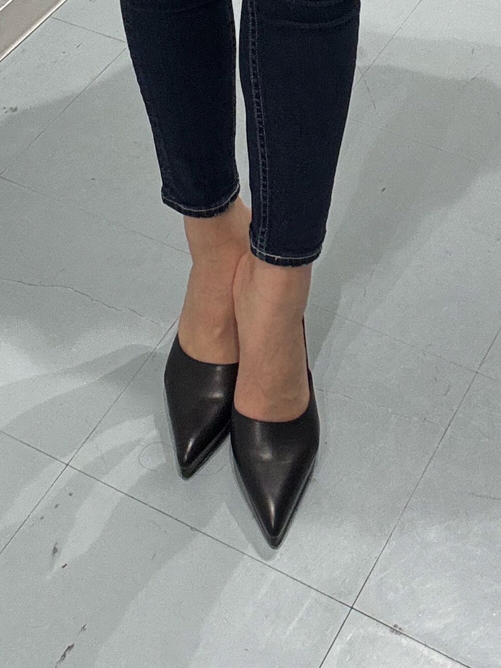 ブルー系のデニムパンツ、ブラック系のニット/セーター、ブラック系のパンプスを着用したレディースの冬コーディネートの6枚目の写真