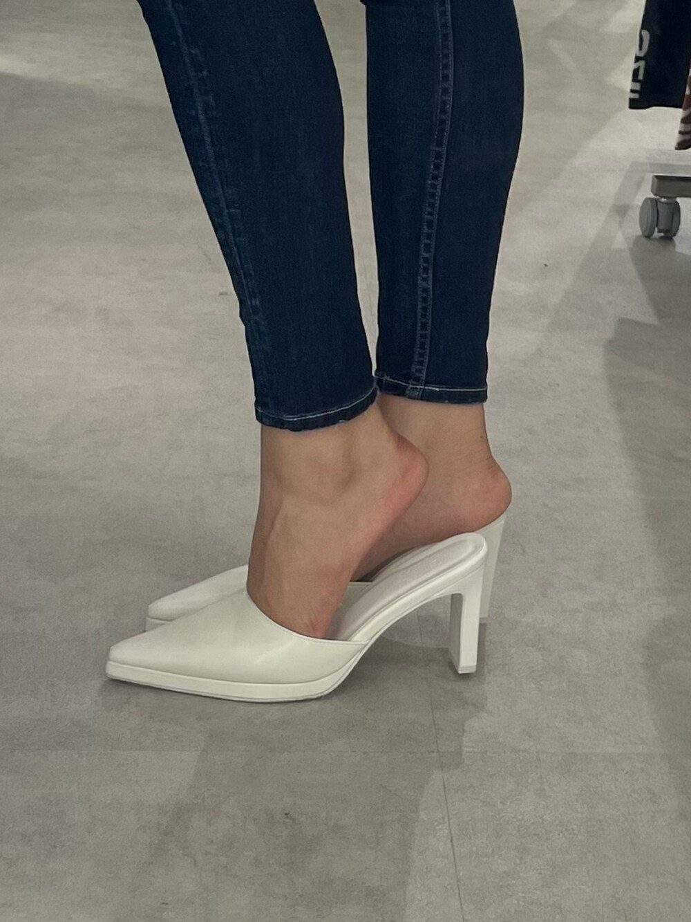 ホワイト系のニット/セーター、ブルー系のデニムパンツ、ホワイト系のパンプスを着用したレディースの冬コーディネートの5枚目の写真