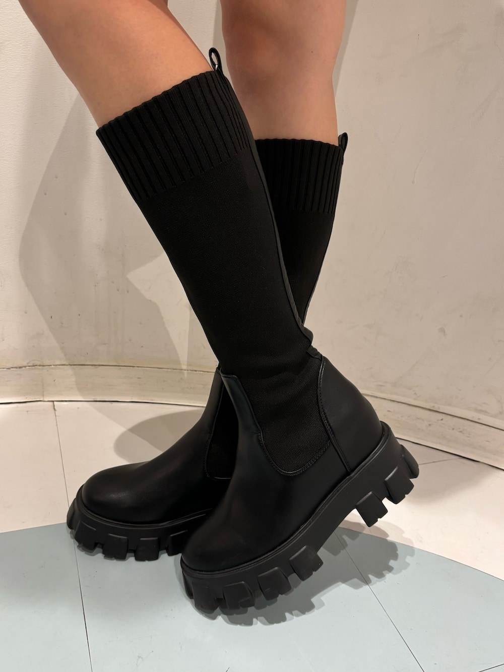 ブルー系のデニムスカート、ブラック系のブーツ、ブラック系のパーカーを着用したレディースの秋コーディネートの8枚目の写真