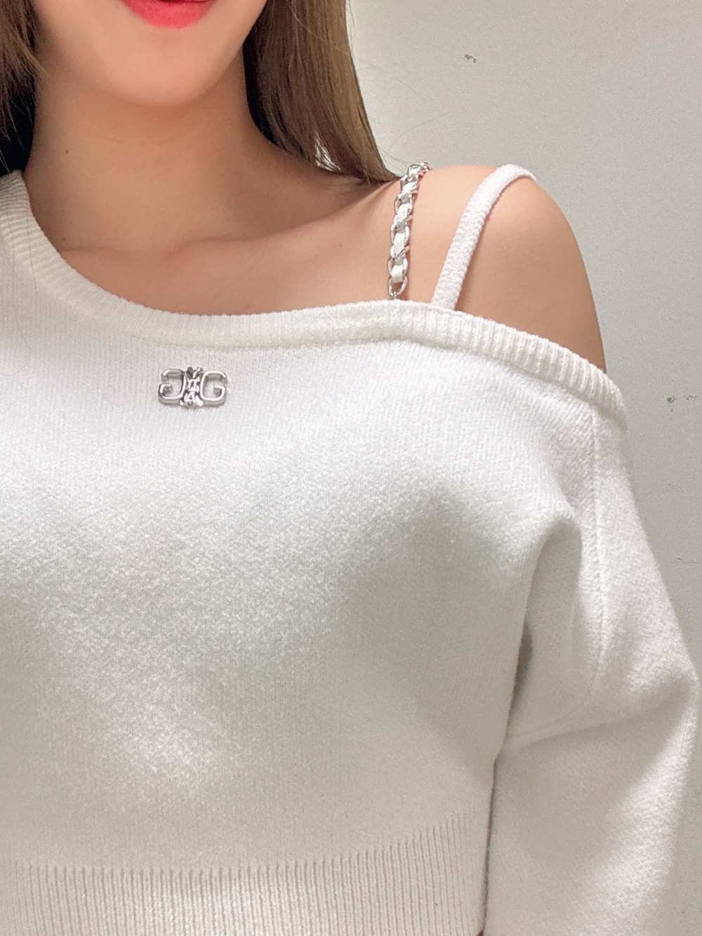 ホワイト系のニット/セーター、ブラック系のデニムスカート、ブラック系のブーツを着用したレディースの冬コーディネートの4枚目の写真