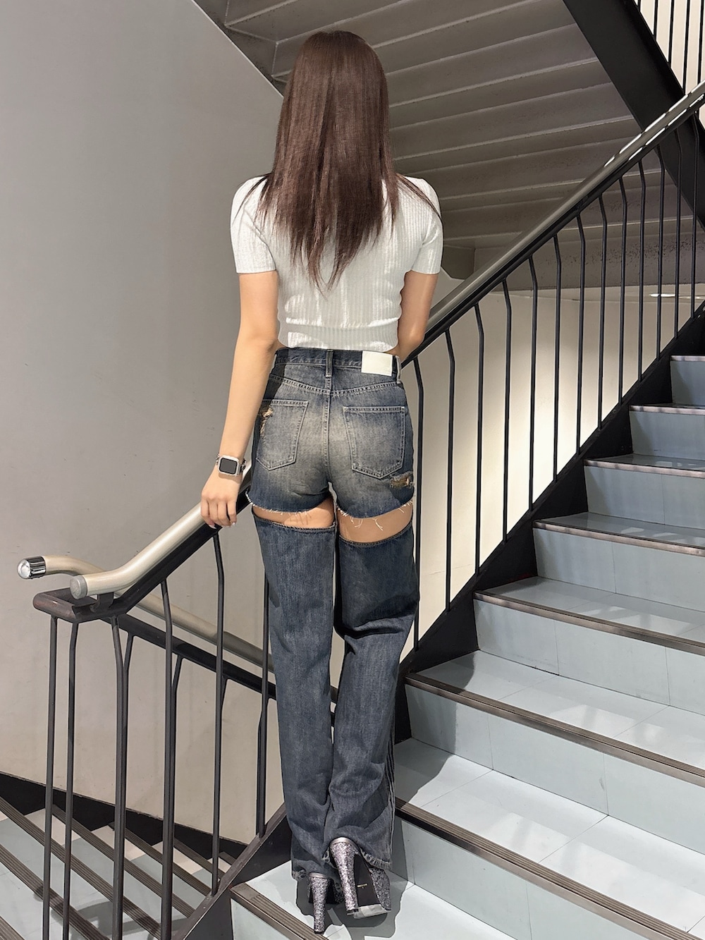 ホワイト系のニット/セーター、ブルー系のデニムパンツ、グレー系のパンプスを着用したレディースの春コーディネートの3枚目の写真