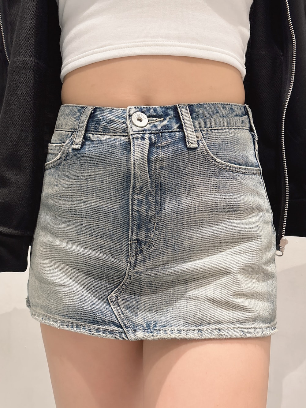 ブルー系のデニムスカート、ブラック系のブーツ、ブラック系のパーカーを着用したレディースの秋コーディネートの6枚目の写真