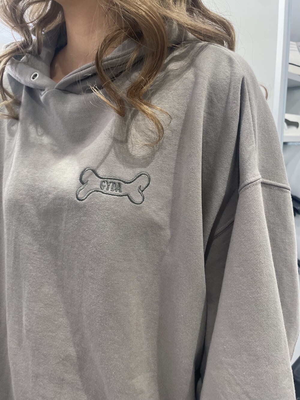 ベージュ系のパーカー、ブラック系のブーツ、ブラック系のスカートを着用したレディースの秋コーディネートの3枚目の写真