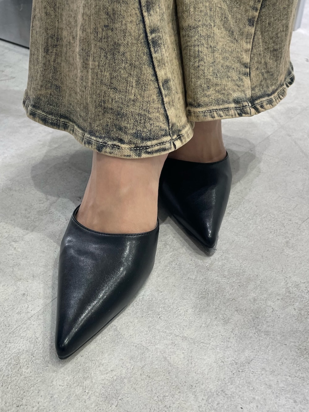 ブルー系のデニムジャケット、ブラック系のパンプス、ブラック系のキャミソールを着用したレディースの秋コーディネートの7枚目の写真